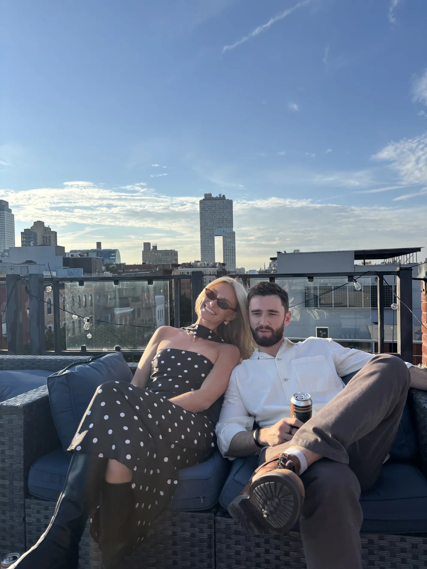 Molly and Mitch sitting together on a rooftop at sunset